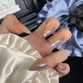 Close-up of long almond gradient nails with glossy orange to blue finish on silk fabric - By1649 / Glue Type