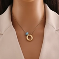 Close-up of a gold necklace with blue evil eye pendant worn over a beige blazer - Gold Letter O