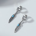 Detail of vintage feather drop earrings with turquoise stone in polished silver steel - Feather Style