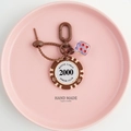 Detail of Monte Carlo poker chip keychain with red translucent dice on pink plate - Brown White-2000 Value