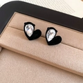 Detalle macro de pendientes de corazón en terciopelo con cristal en estuche de joyas - Negro