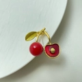 Detail view of the red cherry brooch with gold leaves and glossy resin finish - Style 16 Faceted Red Cherry