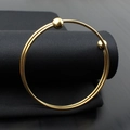 Detail of double-layer gold titanium steel wire bracelet with polished ball ends - Gold