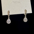Vista macro di orecchini a goccia con zirconi e micro-pavé in finitura argento S925 - Goccia d'argento