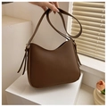 Nahaufnahme der braunen Halbmond-Hobo-Tasche mit Fransen auf modernem Podest - Braun