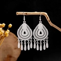 Macro detail of silver ethnic earrings featuring hollow teardrop motifs and leaf tassels - Silver Hollow Butterfly Long Tassel Style (E2873-20)