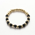 Macro detail of handmade beaded ring with gold spacer beads and faceted black stones - Gold Black