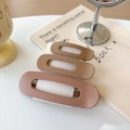 Detailed view of three matte brown hair clips in different sizes on a white card display - Khaki/Earth Yellow