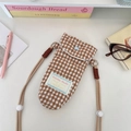 Close-up of quilted check camera bag with heart button and Sorakka Studio label - Plaid Brown