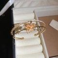 Macro shot of gold double-layer open bangle with zircon firework motif and ball ends - Gold