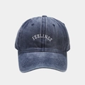 Dettaglio del ricamo FEELINGS sul cappellino da baseball in denim blu lavato - Regolabile / Blu navy