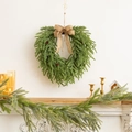Detail of 50cm heart-shaped Christmas wreath with pine needles and burlap bow on mantel - 50cm Brown Bow Cypress Wreath