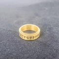Primer plano de runas vikingas grabadas en un anillo giratorio de acero inoxidable - Talla 6 / Dorado