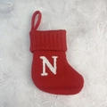 Red knitted Christmas stocking featuring a white plush letter N with hanging loop - Letter N