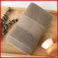 Thick brown cotton towel with gold embroidery stripes on a wooden bath tray - Cotton Gold Border Grey (Towel)