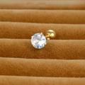 Macro shot of 4-prong round zircon stud earring with gold finish and ball screw back - 5mm / Gold