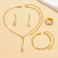 Piatto di elegante set di gioielli dorati con strass trasparenti su sfondo di tessuto - Set Oro 446+785+424-2