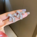 Dettaglio orecchini a fiocco in argento con zirconi scintillanti indossati da modella - Perno in Argento - Orecchini a Bottone con Fiocco in Zircone Argento / Argento