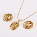 Dettaglio macro del ciondolo a spirale ovale dorato e set di orecchini a lobo - Oro