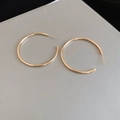 Close-up of golden C-shaped minimalist hoop earrings with a polished metallic finish - 4cm / Gold / Silver Needle