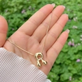 Glossy 18K gold plated bubble letter R pendant necklace for women in hand - Gold R