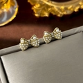 Elegant gold bow earrings with small white pearls and crystals on a gray display box - 33# Bow Pearl Studs