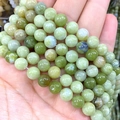 Handheld view of natural light green round stone beads for DIY jewelry making - China Jade / 4mm Approx 93pcs