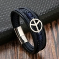 Dettaglio del bracciale in pelle intrecciata blu scuro con segno di pace in metallo e chiusura - Blu Scuro/Argento