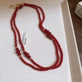 Close-up of double-layer red beaded necklace with golden spacers and lobster clasp - Double Layered Beaded Sweater Chain / Gold-Red
