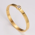 Detailed close-up of a gold stainless steel bangle with a single inset round zircon stone - Gold 6mm