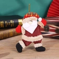 Dettaglio di Babbo Natale in peluche con trama di iuta rossa su un tavolo di legno scuro - Grande Babbo Natale