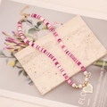 Collana bohémien in dischi di argilla colorati con ciondolo a cuore e perle su marmo - Rosa Misto