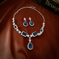 Dettaglio di un set di gioielli di lusso con cristalli blu su seta marrone - Ago in Argento - Blu (Set da 2 Pezzi)