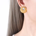 French style gold ribbed round earrings with moonstone inlay on a female model - Moonstone (Gold Tone)