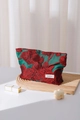 Detail der Make-up-Tasche aus rotem Blumen-Jacquard mit H & R BAG Logo auf Holztablett - Groß / Rot
