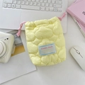 Detailed view of quilted cotton camera pouch with pink drawstring on white desk - Quilted Cloud Yellow