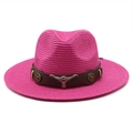 Detail of pink straw cowboy hat featuring brown leather band and silver bull head emblem - Rose Red