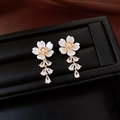 Detail of flower drop earrings with white shell petals and sparkling zircon tassel - Gold Five Petal White Flower Pearl Tassel Style