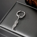 Macro shot of retro silver feather pendant earring on dark textured jewelry box background - Feather