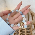 Pulsera de cuentas azul océano con un colgante brillante de cola de sirena en oro - Cola de Pez