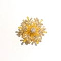 Detailed close-up of a rotating snowflake brooch with gold plating and sparkling zircons - Golden Yellow Brooch