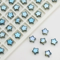 Detailed view of 8mm blue crystal star beads with iridescent finish on a white tray - Plated Ink Blue