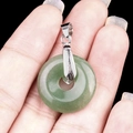 Green aventurine jade donut pendant necklace with silver clasp held by hand - 20mm Green Aventurine