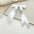 Detail einer eleganten weißen Satin-Haarklammer mit doppelter Schleife und Band - Weiß