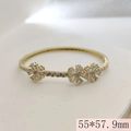 Golden open bangle with zircon flowers and dimensions 55x57.9mm on stone texture - 55x57.9mm / White