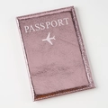 Close-up of rose gold crackle leather passport cover with white embossed text - Pink
