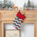 Dettaglio calza di Natale in maglia con risvolto rosso, pompon verdi e motivo a onde - Calza a Righe Rosse e Verdi
