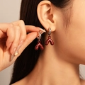 Close-up of deep red heart pendant earrings with silver hoops on model - Deep Red 3D V-Shaped Dangle Hoop Earrings (925 Sterling Silver Earring Post)