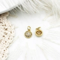 Macro view of gold micro-pave cubic zirconia charms with hollow back on lace and feathers - Round Zirconia