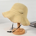 Beige woven straw sun hat with wavy brim and side bow detail on a wooden stand - Beige Wavy Edge